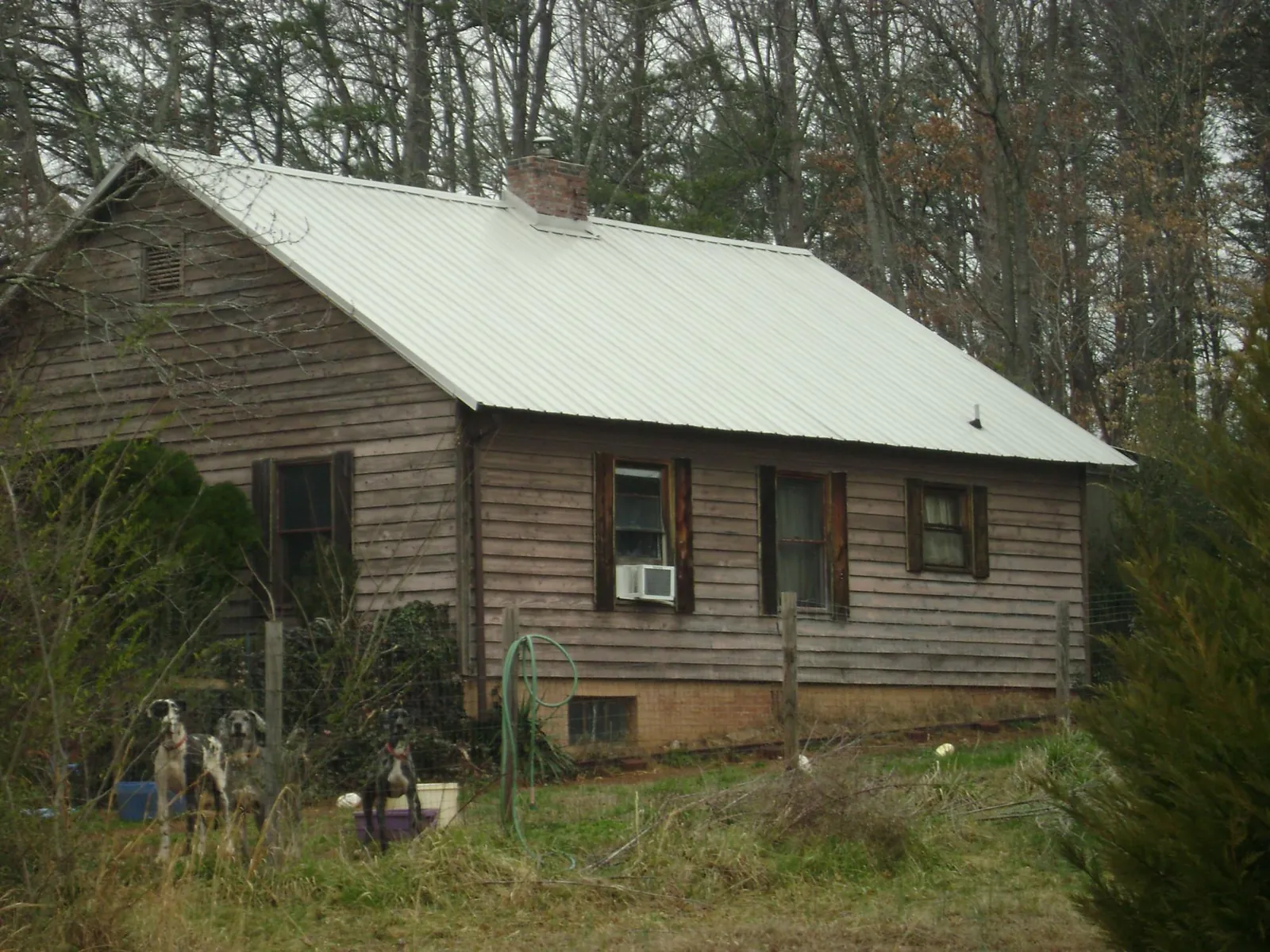 White metal roof on an old wood sided farmhouse, from a Metal Roof Installation job in Point Clear